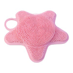 A single pink silicone starfish-shaped brush with two distinct bristle textures is displayed against a white background.