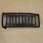 A white and black mesh fabric organizer is shown unfolded on a light wooden surface.