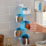 A hand pulls out a clear container of red spice from a blue 5-layer rotating spice rack on a tiled wall