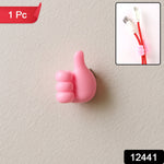 Pink thumb hook cable holder securely mounted on a wall surface