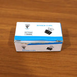 Black metal binder clip on stack of documents