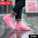 A person wears pink silicone shoe covers on a wet sidewalk; a red banner says "Large, 1 Pair" and a black box has "16184".