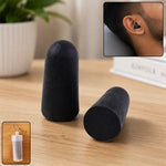 Two black foam earplugs stand on a wooden surface, with a man wearing one in his ear and a clear case shown in insets.