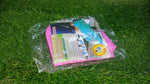 A clear plastic package containing pink and blue silicone shoe covers with product information, resting on green grass.