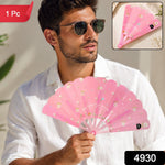 A man in a white shirt and sunglasses holds an open pink fan with white flowers and text, with a small folded fan in the top
