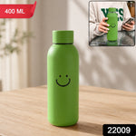 Green glass water bottle with a smiley face on a wooden table, with an inset showing a person holding a similar bottle. The