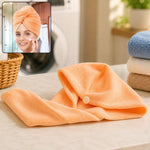 An orange microfiber hair towel wrap with a button closure, with an inset showing a woman wearing a similar towel.