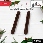 Two brown anti-slip eyeglass ear grips displayed on a white wooden surface with festive green and red decorations.