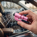 A pink emergency tool with a black tip is held by a hand, shattering a car window, with a smaller image of the tool in the