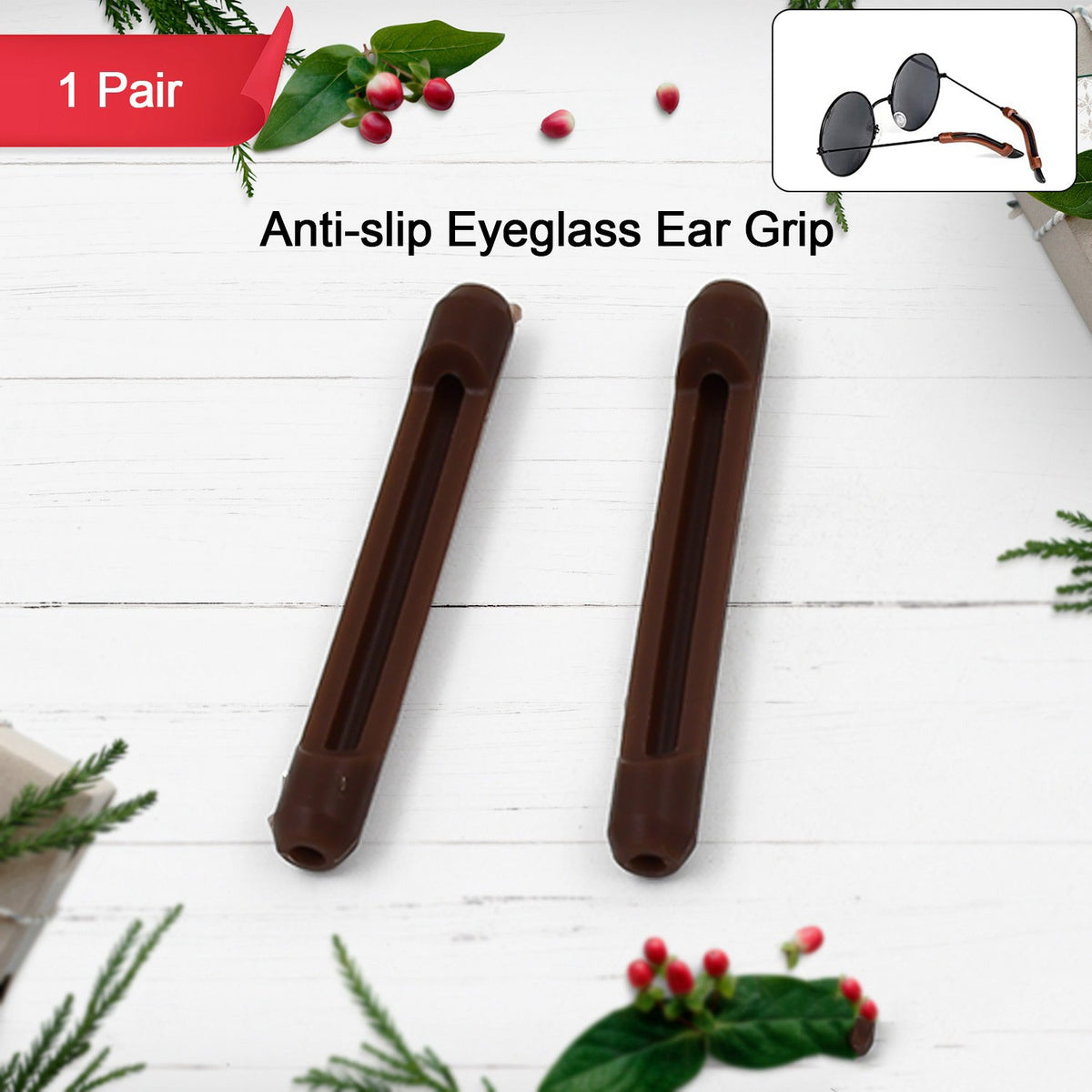 Two brown anti-slip eyeglass ear grips on a white wooden background with holiday foliage and berries.