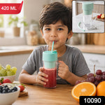 A young boy sips a red smoothie from a clear blender bottle with a mint green lid and straw inkitchen setting.