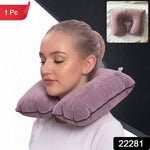A woman wears an inflated purple velvet U-shape neck pillow with a clear valve visible on the right side.