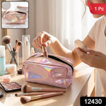 A holographic pink makeup bag with a zipper is open on a marble surface surrounded by makeup brushes and a mirror.