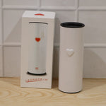 A white thermal tumbler with a heart detail stands next to its product box, which also features a heart design.